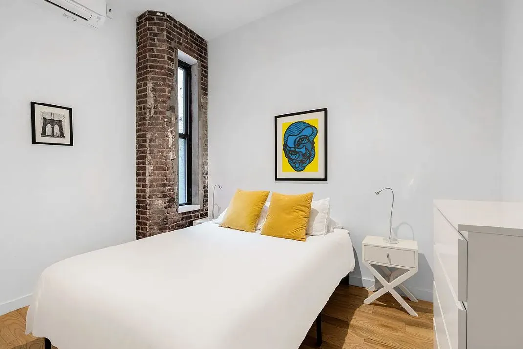 a bedroom with a bed and painting on the wall