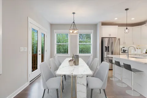 a dining room with furniture a chandelier and wooden floor