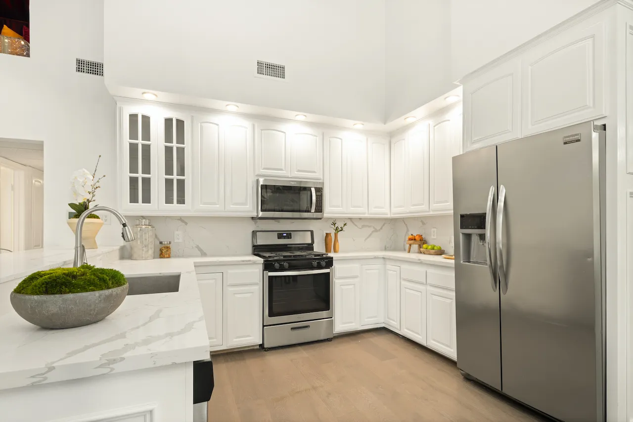 a kitchen with stainless steel appliances granite countertop a refrigerator sink and stove