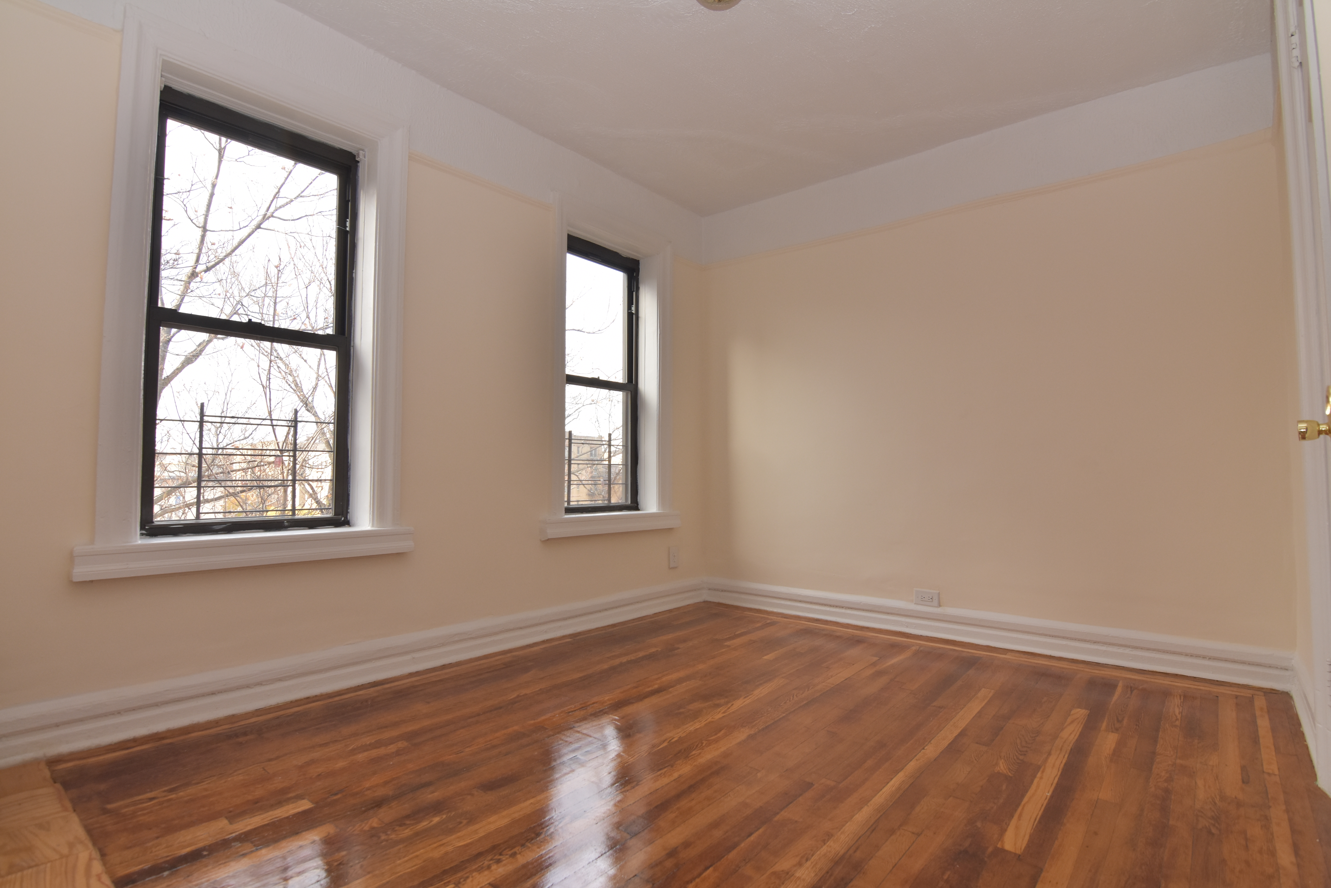 20 Laurel Hill Terrace, Unit 6A Manhattan, NY 10033 - Photo 6 of 11 an empty room with wooden floor and windows