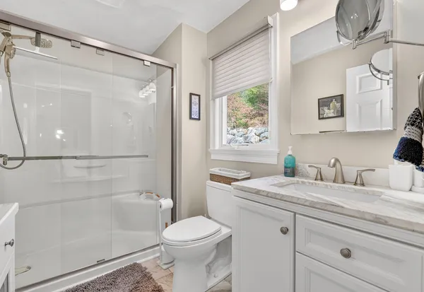 a bathroom with a granite countertop sink a toilet and shower
