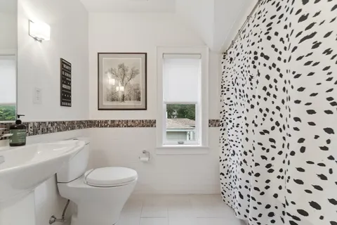 a bathroom with a toilet a sink and a window