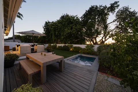 a view of a patio with table and chairs with wooden floor and fence