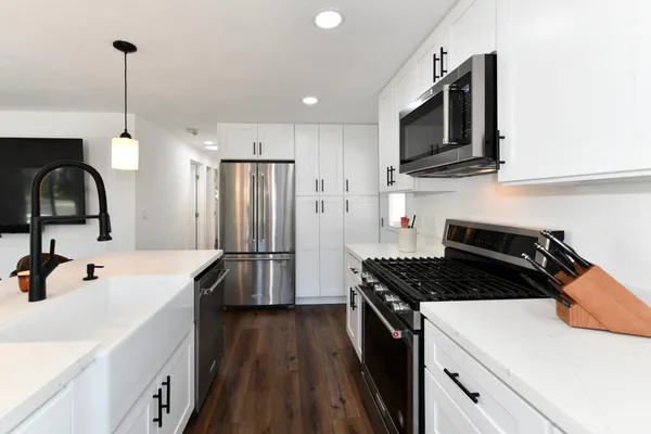 a kitchen with stainless steel appliances granite countertop a sink stove and refrigerator