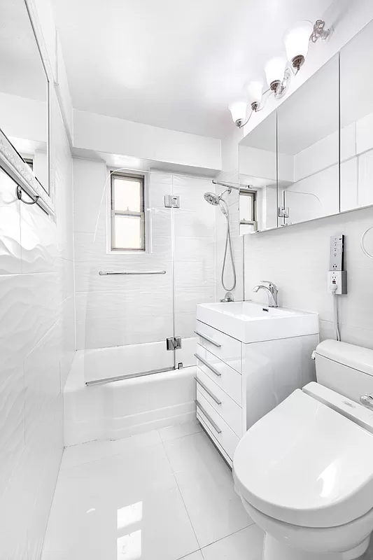 225 East 46th Street, Unit 12G Manhattan, NY 10017 - Photo 4 of 19 a bathroom with a sink a toilet and bathtub