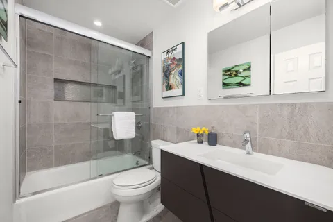 a bathroom with a sink a toilet and shower