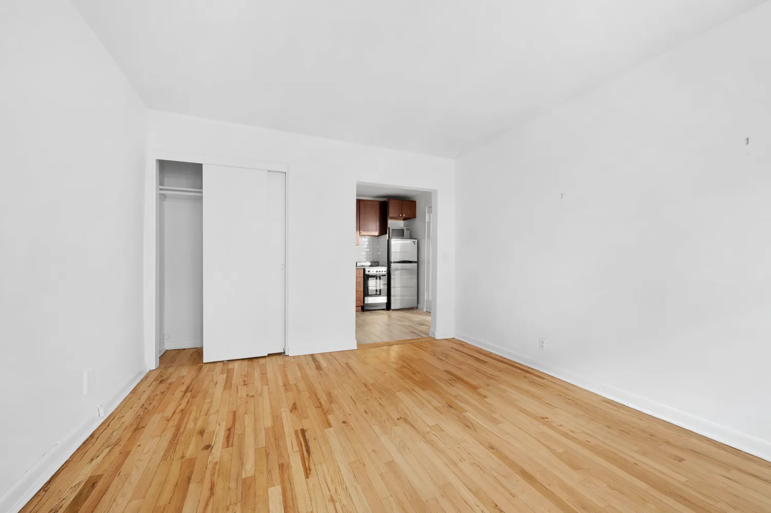 a room with a bed and wooden floor