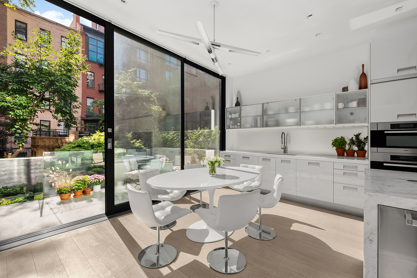 184 East 75th Street Manhattan, NY 10021 - Photo 5 of 20 a kitchen with a table chairs stove and cabinets