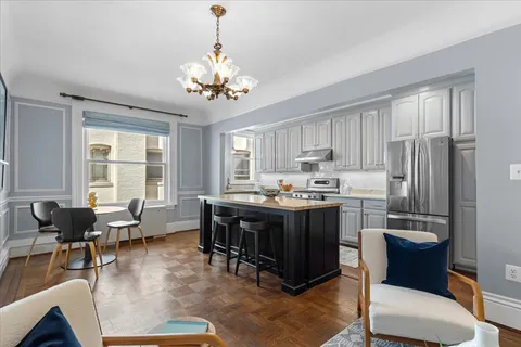 a kitchen with a table chairs refrigerator and microwave