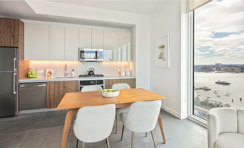 a kitchen with a table chairs and refrigerator