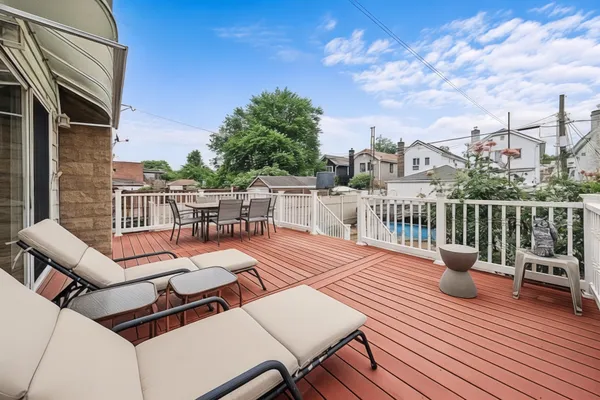 a view of a roof deck with table and chairs couches with wooden floor