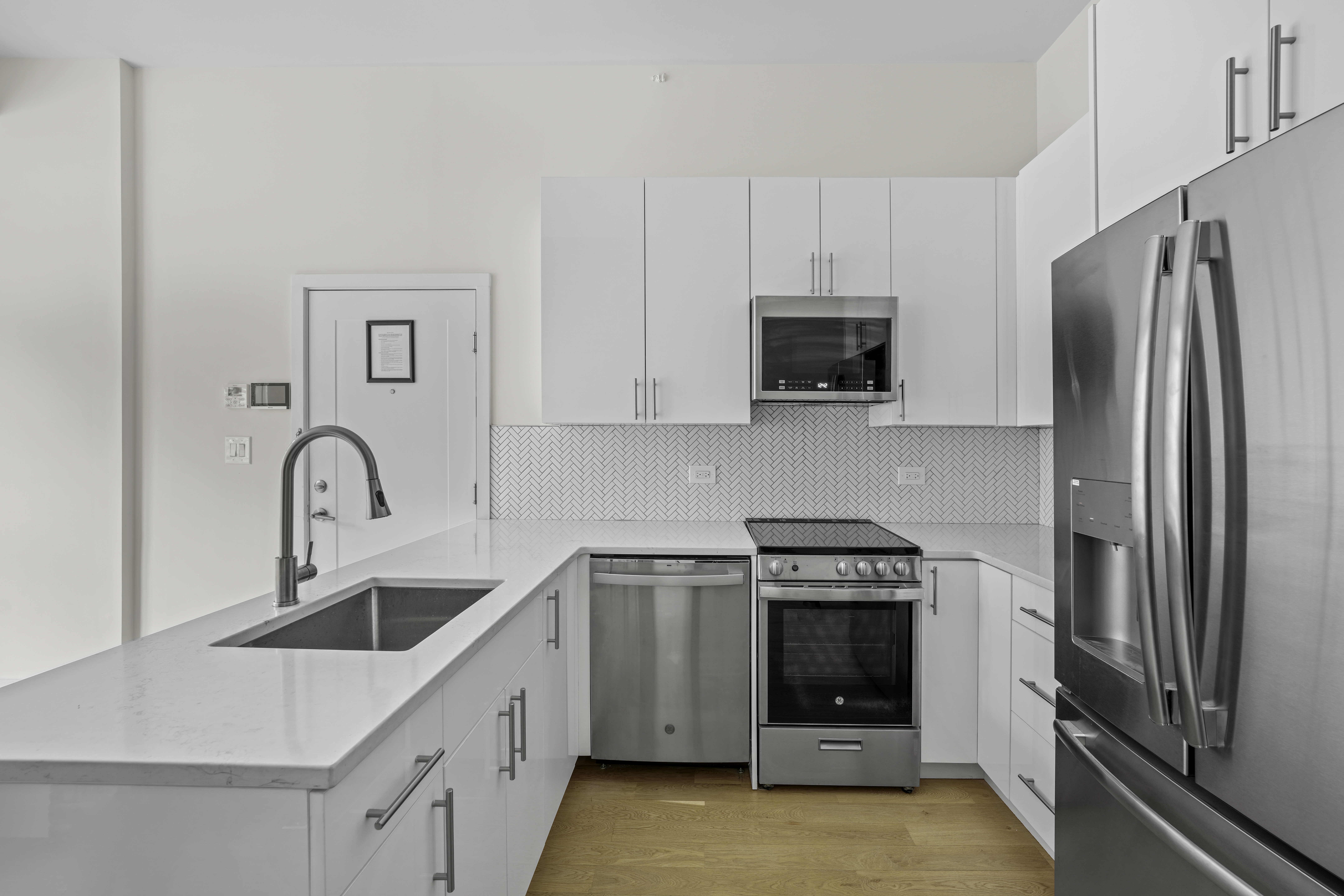 950 St Nicholas Avenue, Unit 1 Manhattan, NY 10032 - Photo 4 of 16 a kitchen with white cabinets and stainless steel appliances