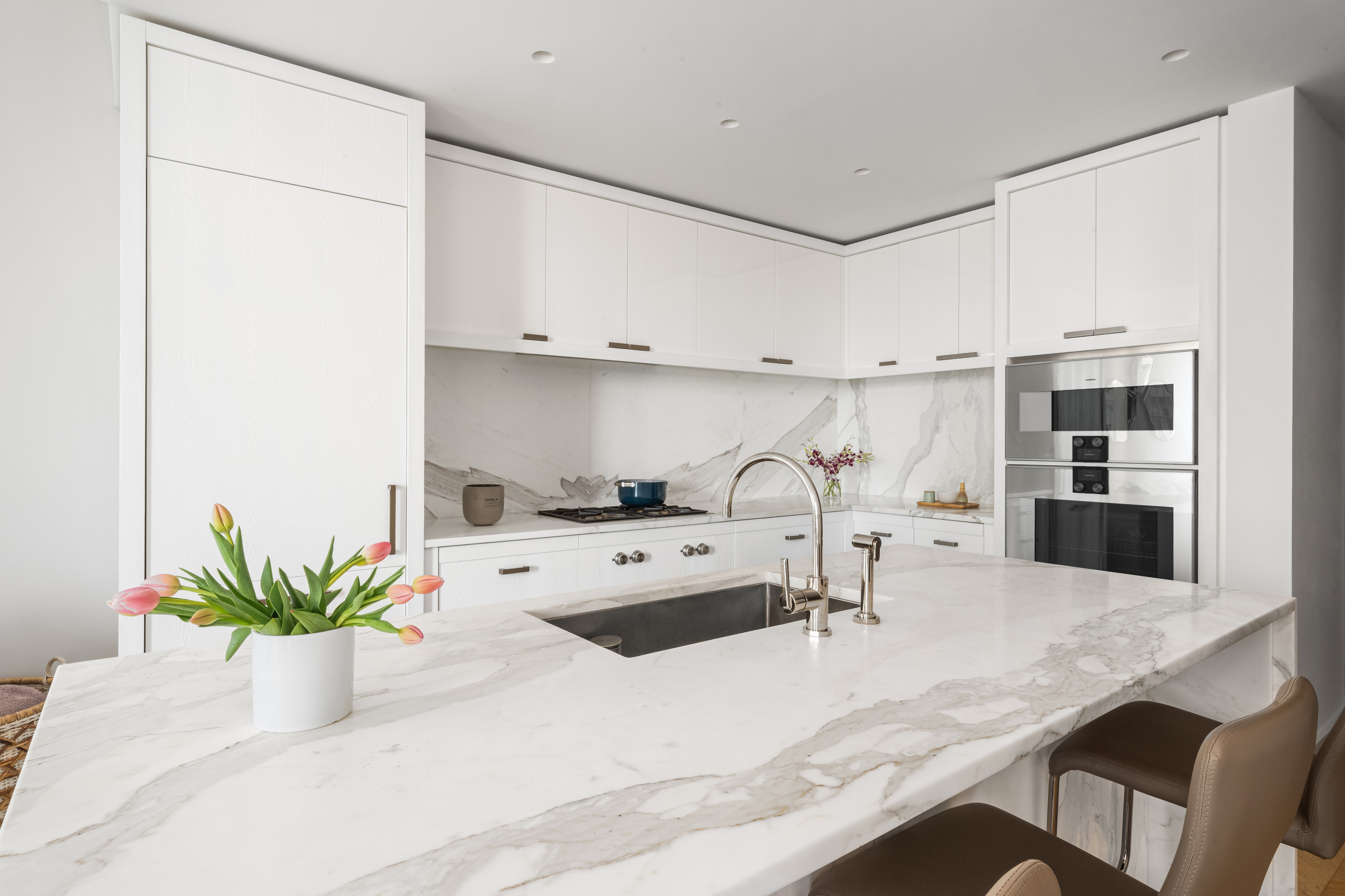 500 West 18th Street, Unit EAST 20C Manhattan, NY 10011 - Photo 5 of 28 a kitchen with stainless steel appliances kitchen island granite countertop a sink a stove and white cabinets