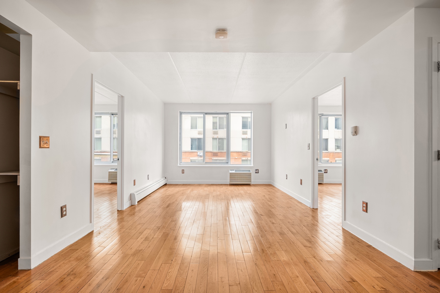 29 West 138th Street, Unit 2D Manhattan, NY 10037 - Photo 1 of 10 wooden floor in an empty room with a window