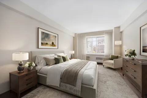 a bedroom with bed couch and window