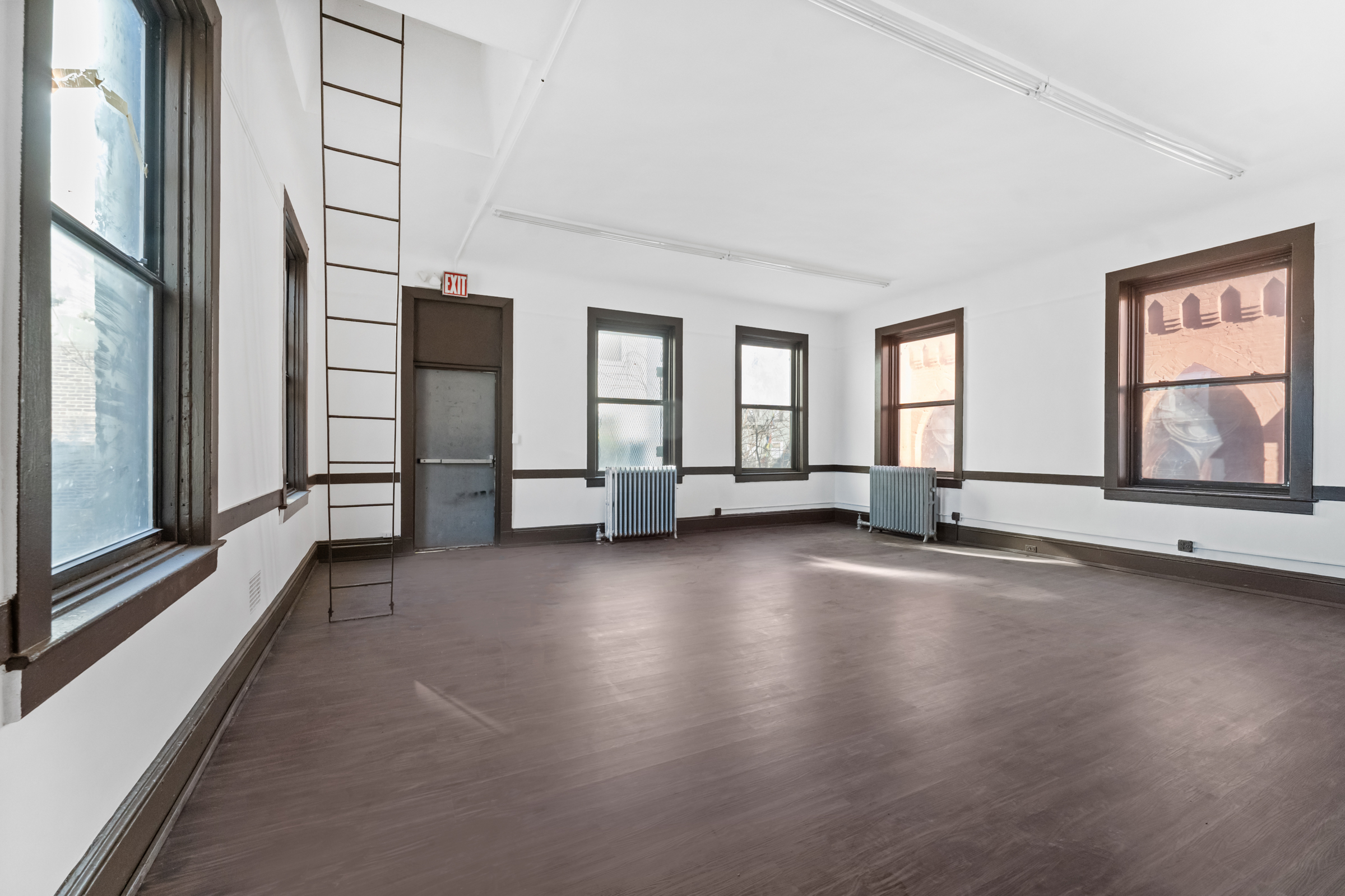 187 Maujer Street Brooklyn, NY 11206 - Photo 6 of 12 an empty room with wooden floor and windows
