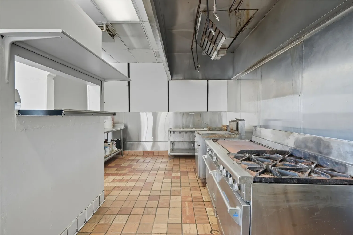 a view of a hallway with wooden floor and a bathroom