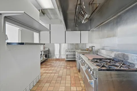a view of a hallway with wooden floor and a bathroom