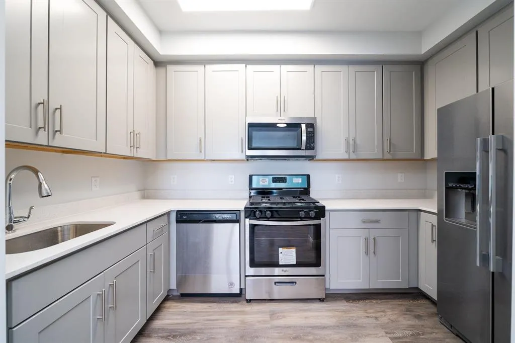 a kitchen with stainless steel appliances granite countertop a stove a sink and a refrigerator