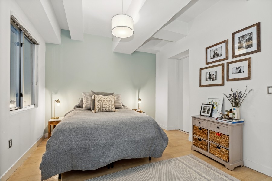 119 Fulton Street, Unit 2B Manhattan, NY 10038 - Photo 6 of 10 a bedroom with a bed and a chandelier