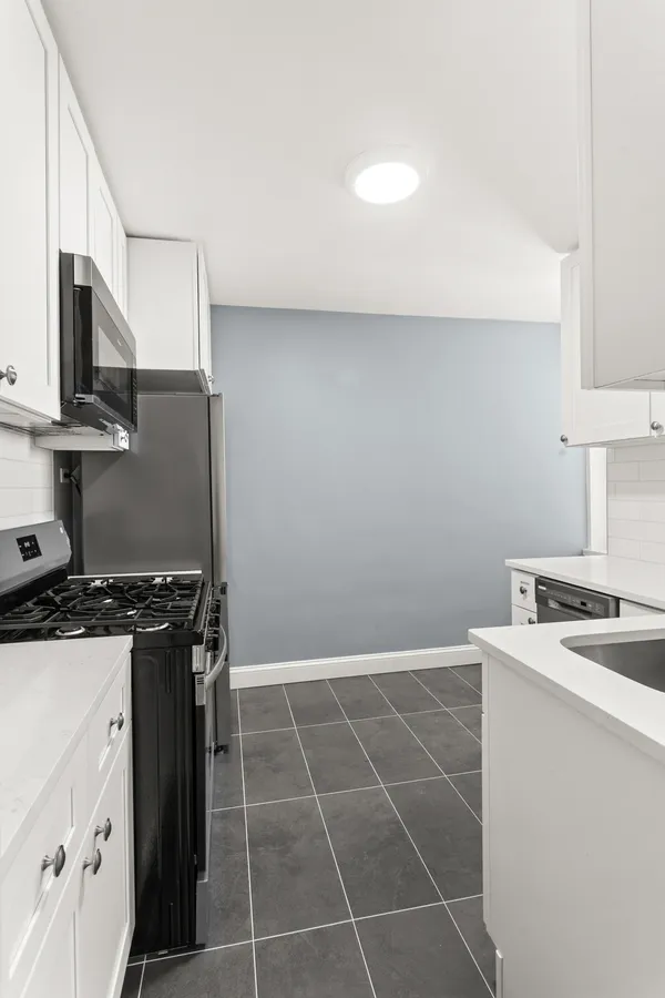 a kitchen with a stove a sink and a microwave