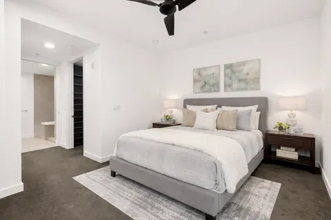 a bedroom with a bed and painting on the wall