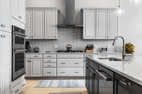 a kitchen with stainless steel appliances granite countertop a stove a sink and a microwave