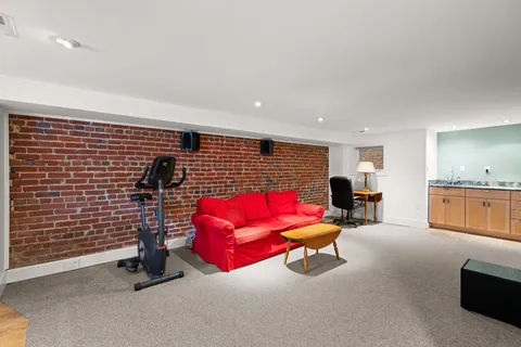 a living room with furniture gym equipment and a rug