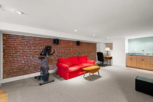 a living room with furniture gym equipment and a rug