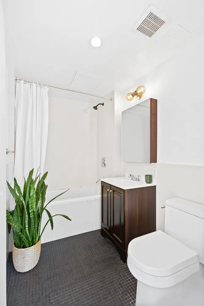 a bathroom with a granite countertop sink a toilet and mirror