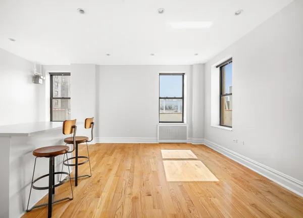 a view of an empty room with glass door and wooden floor