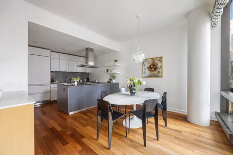 a kitchen with stainless steel appliances kitchen island a table and chairs in it