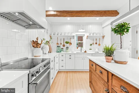 a kitchen with stainless steel appliances granite countertop a stove a sink a refrigerator dining table and chair