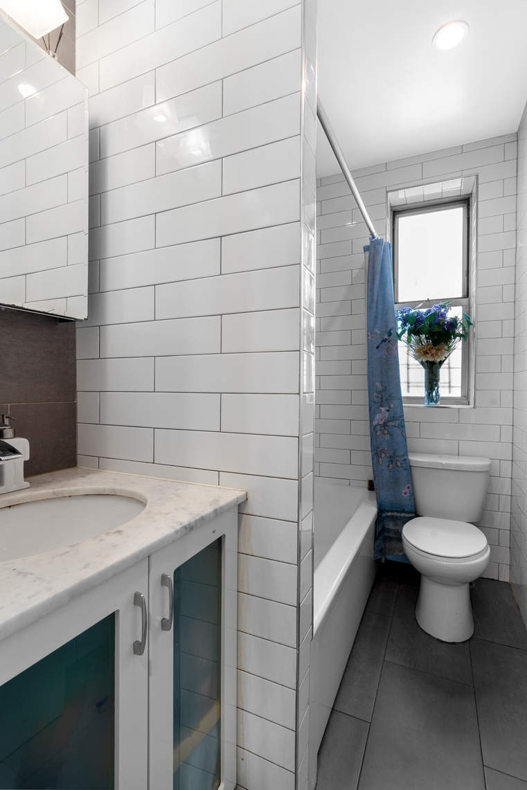 156-08 Riverside Drive West, Unit 2C Manhattan, NY 10032 - Photo 5 of 10 a bathroom with a sink a toilet and shower