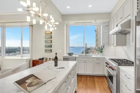 a kitchen that has a lot of cabinets in it and wooden floor