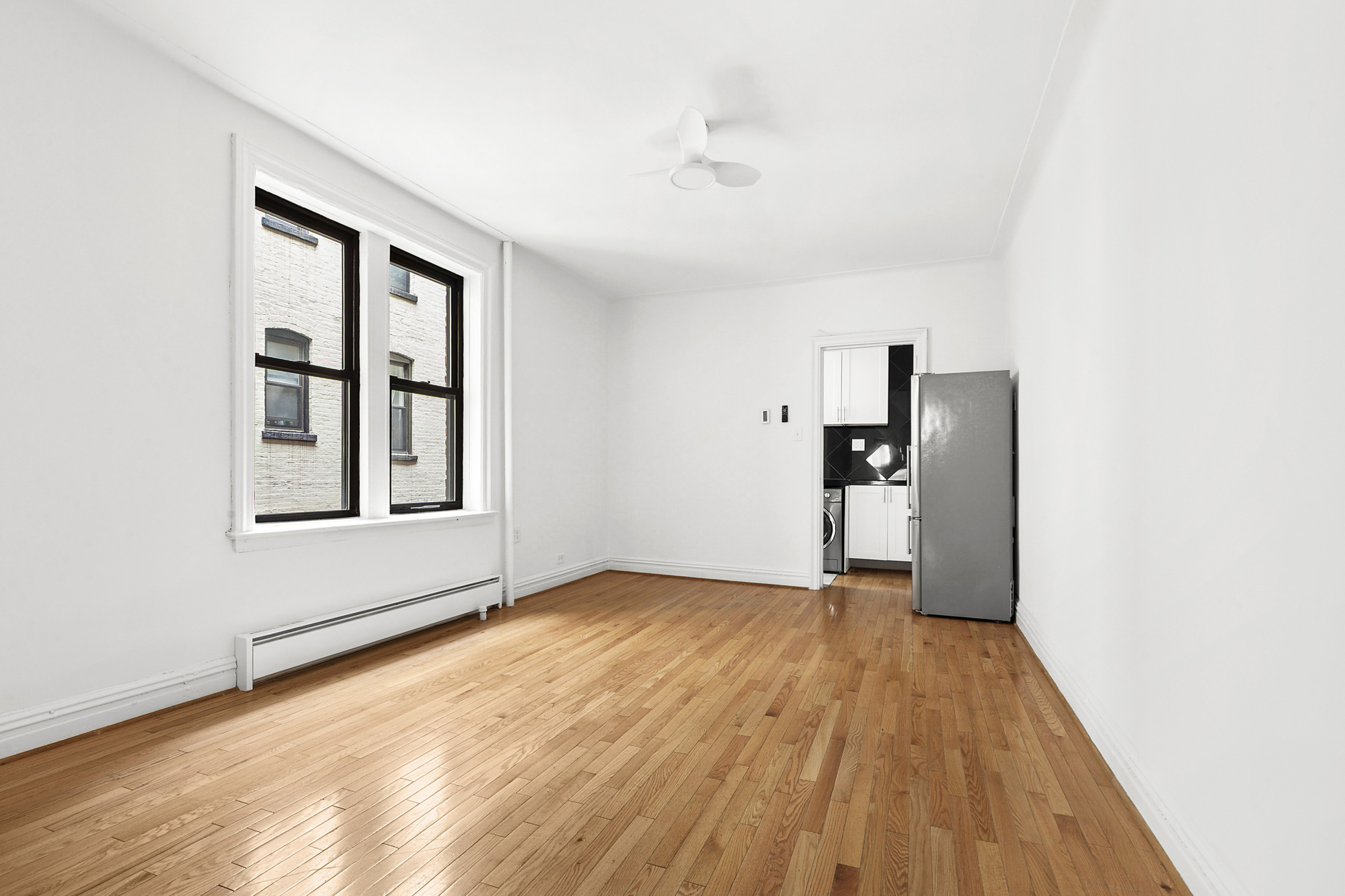 205 West 10th Street, Unit 3D Manhattan, NY 10014 - Photo 2 of 7 a view of an empty room with window and wooden floor