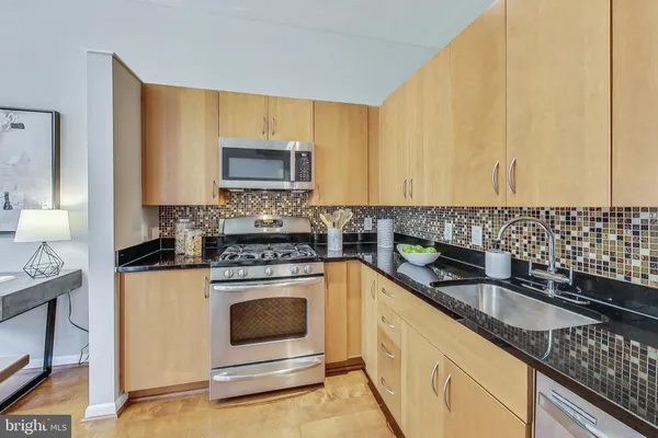 a kitchen with granite countertop a stove sink and cabinets
