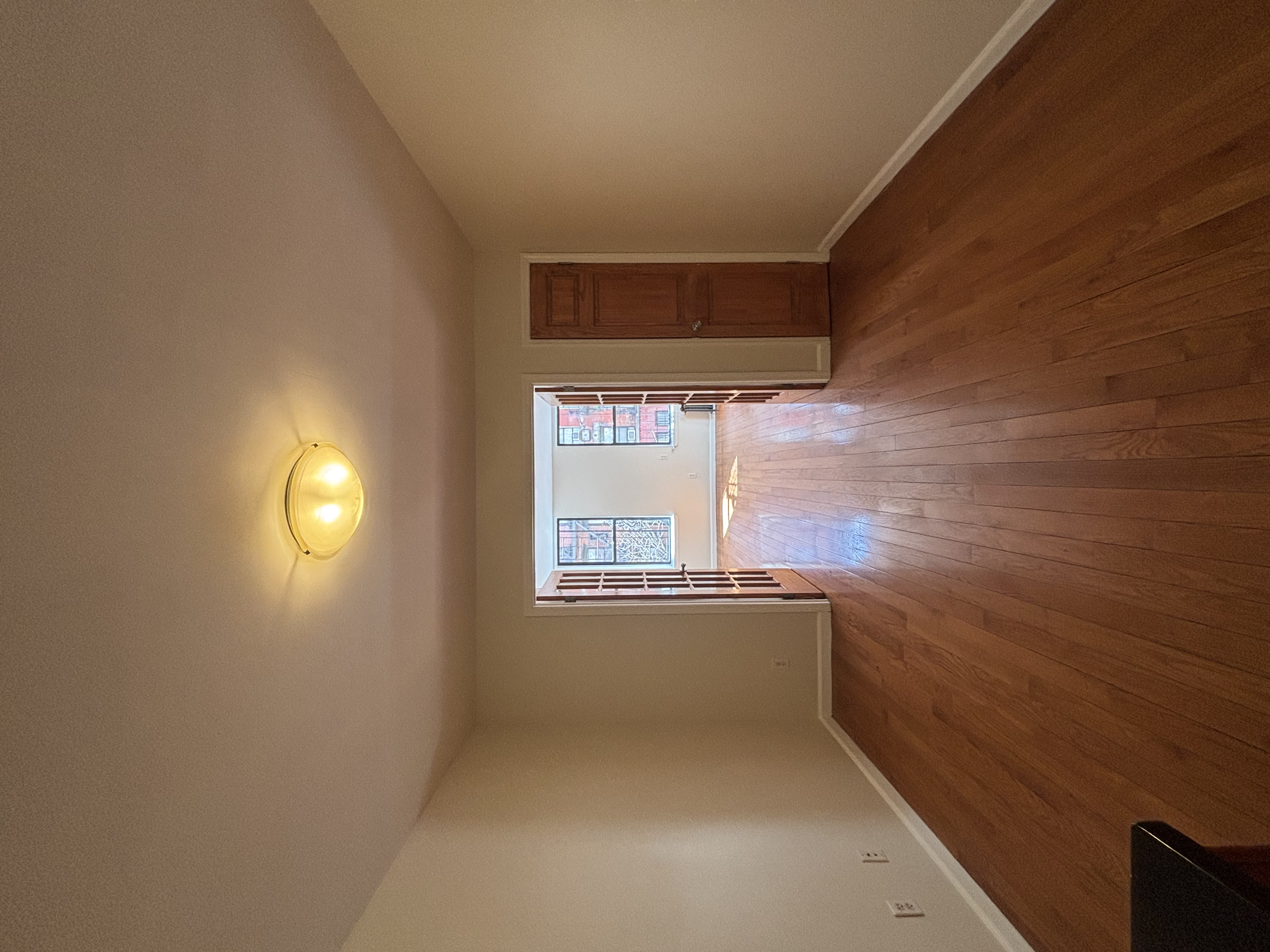 99 St Marks Place, Unit 4B Manhattan, NY 10009 - Photo 2 of 10 a view of an empty room with wooden floor and a window