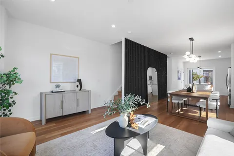a living room with furniture kitchen and a potted plant