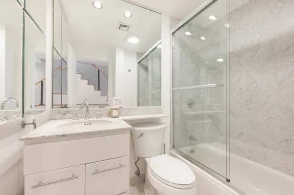 a bathroom with a sink a toilet and shower