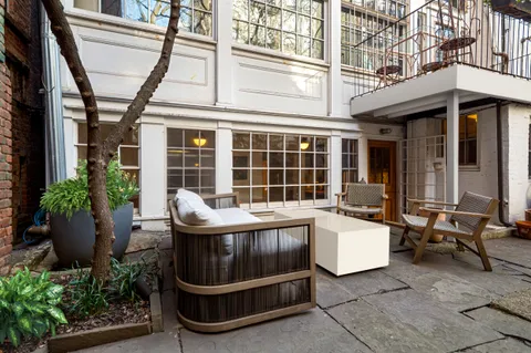 a view of a patio with a table and chairs and potted plants