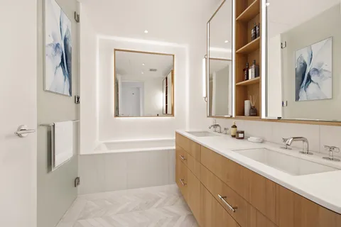 a bathroom with a double vanity sink mirror and bathtub
