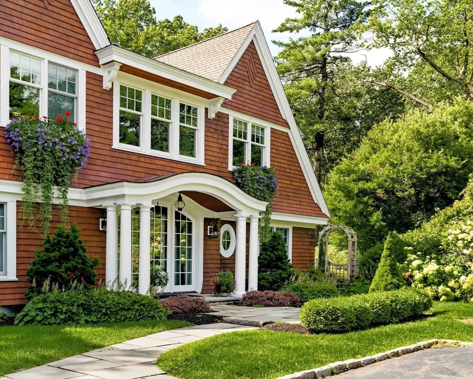 a front view of a house with a yard and potted plants