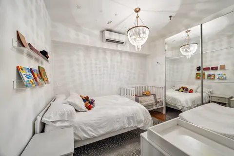 a bedroom with two beds and a chandelier