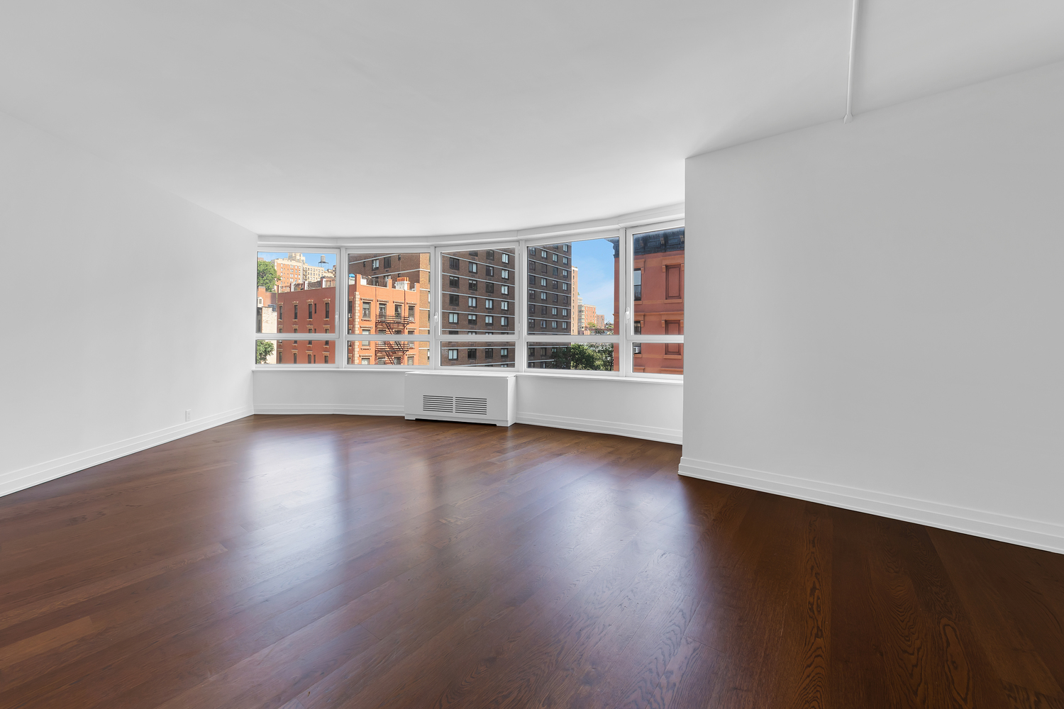 200 East 94th Street, Unit 315 Manhattan, NY 10128 - Photo 2 of 25 an empty room with wooden floor and windows