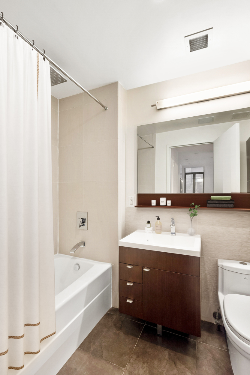 148 East 24th Street, Unit 6E Manhattan, NY 10010 - Photo 4 of 12 a bathroom with a sink a toilet and a bathtub