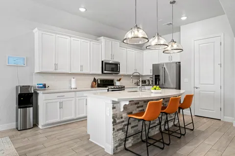 a kitchen with cabinets a sink and white appliances