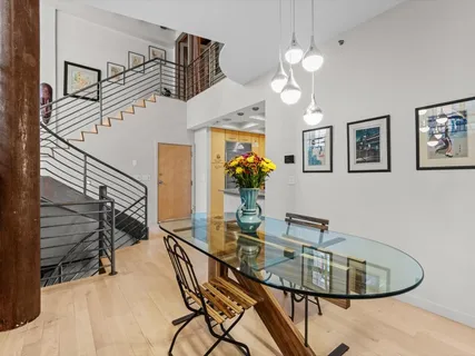 a dining room with wooden floor a chandelier a wooden table and chairs