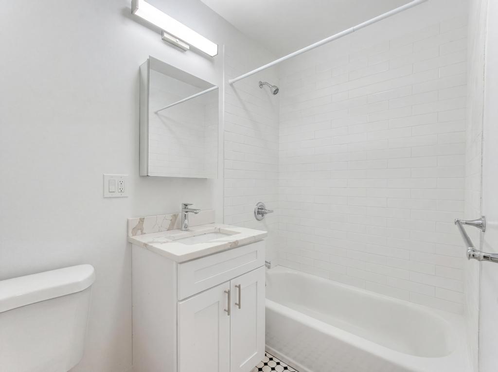 231 East 60th Street, Unit 2 New York, NY 10022 - Photo 5 of 9 a bathroom with a sink a toilet and a bathtub