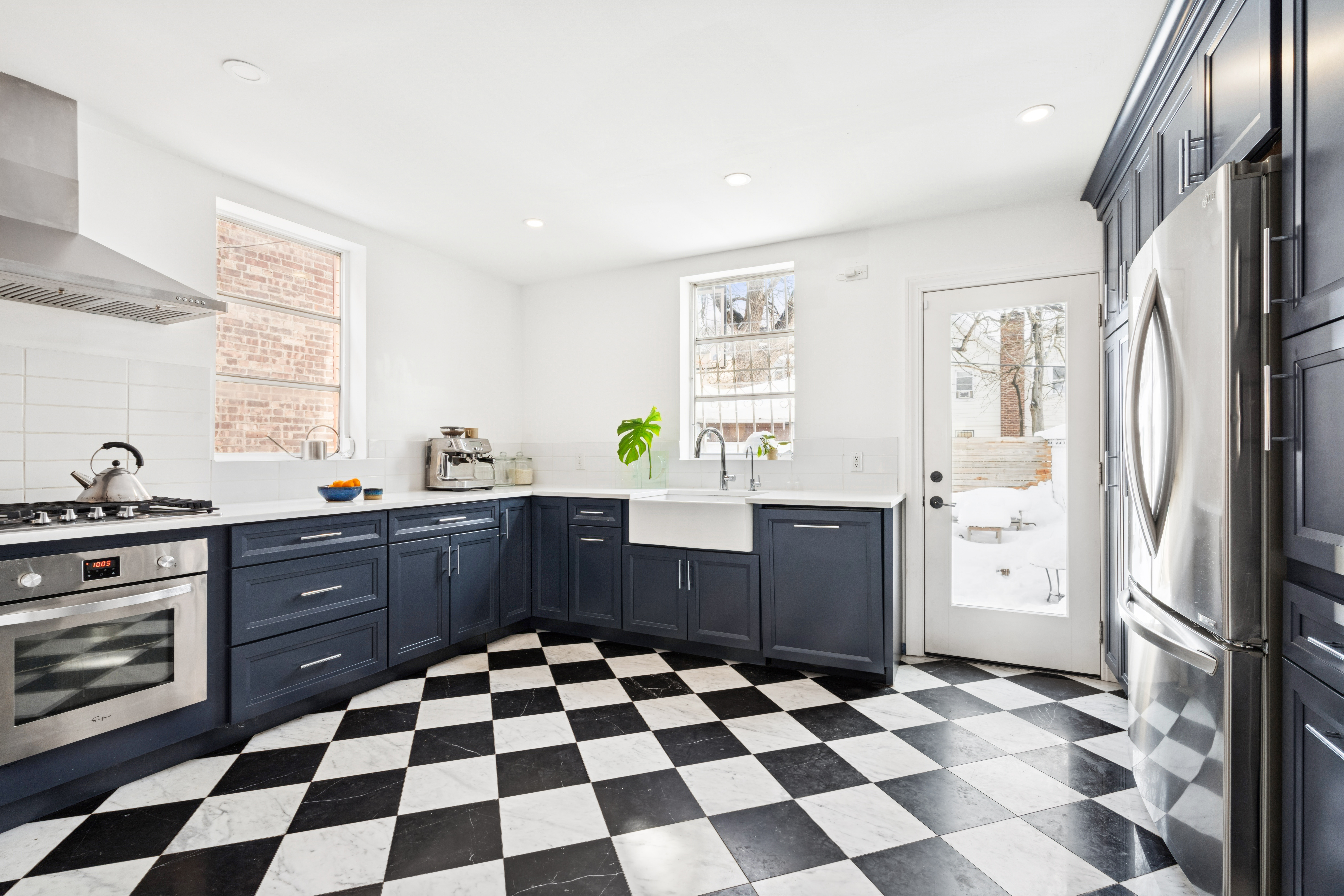527 East 38th Street Brooklyn, NY 11203 - Photo 4 of 15 a kitchen with a checkered floor and white cabinets